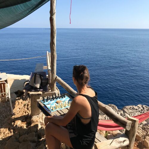 A woman playing chess on top of Odysseus Cave, panoramic view, Island Mljet
