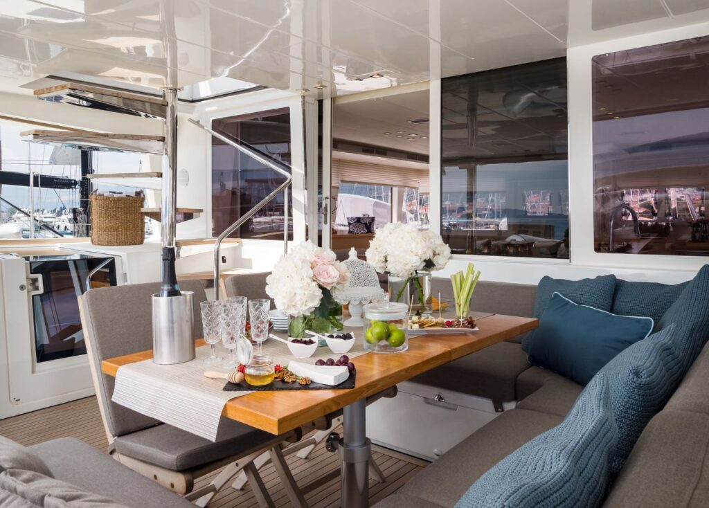 Cockpit of a sailing yacht, teak table with welcome drinks and snacks.