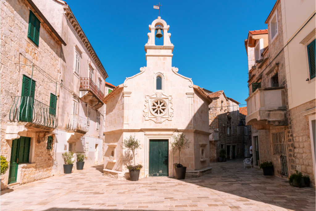 Church and square of St. John surrounded by stone houses and scenic balconies. Jelsa is fourth on this list of 5 charming towns on the Hvar island.